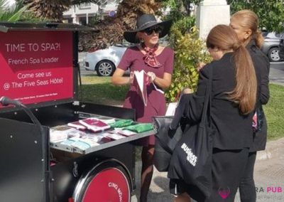 Hôtesse et vélo triporteur pour Cinq Mondes - Riviera Pub - Street Marketing Nice, Cannes, Monaco